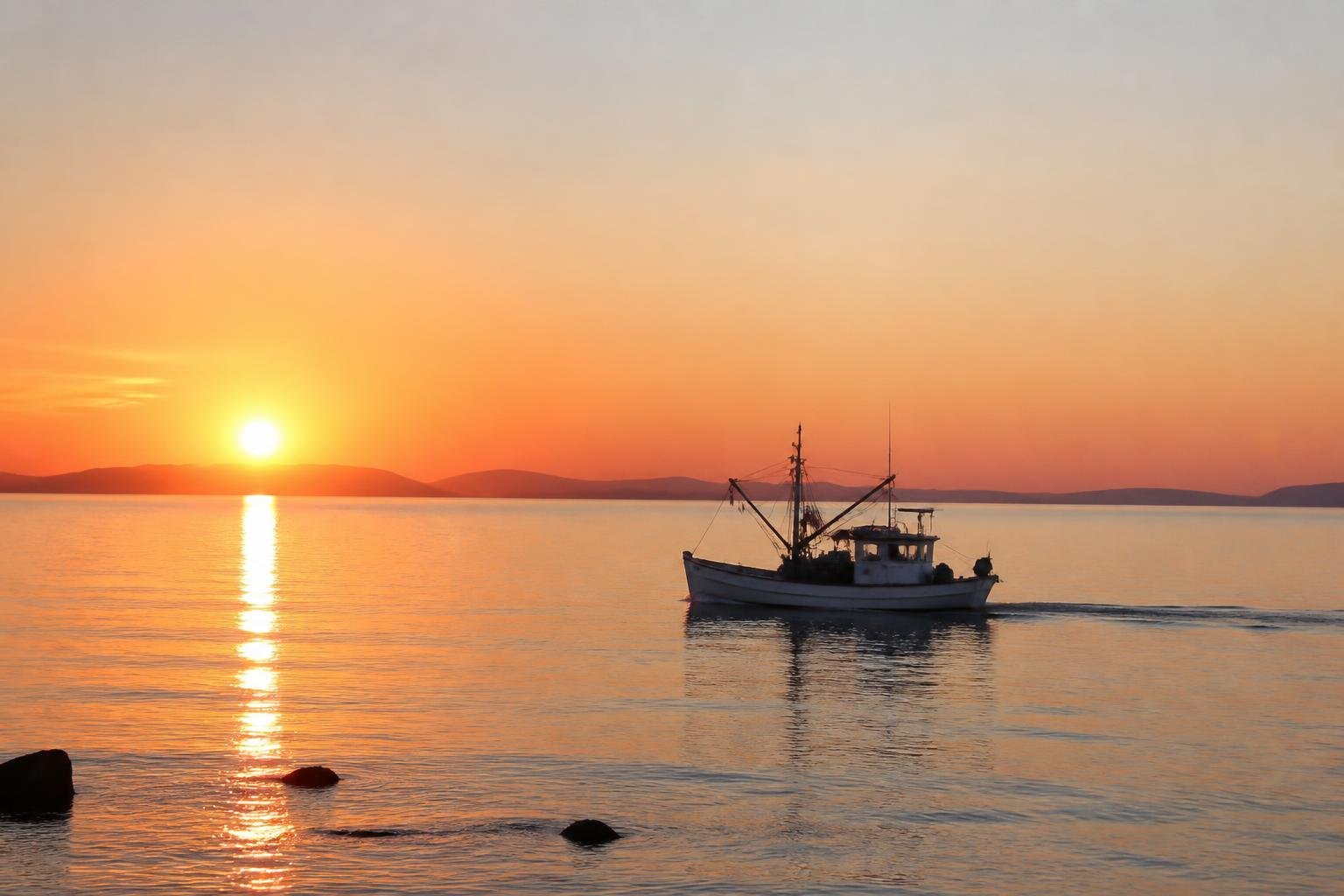 Bateau de pêche côtier dans la baie au lever du soleil